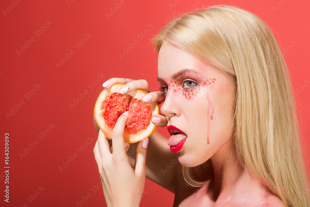 pretty girl with stylish makeup lick grapefruit, vitamin