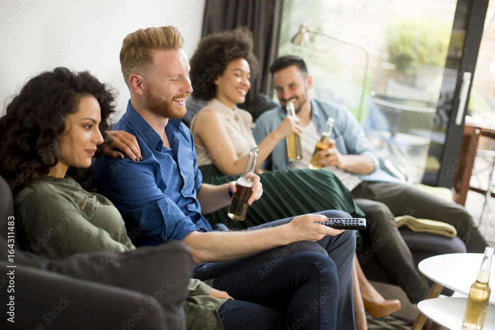 Group of friends watching TV, drinking cider and having fun Group of friends watching TV, drinking cider and having fun