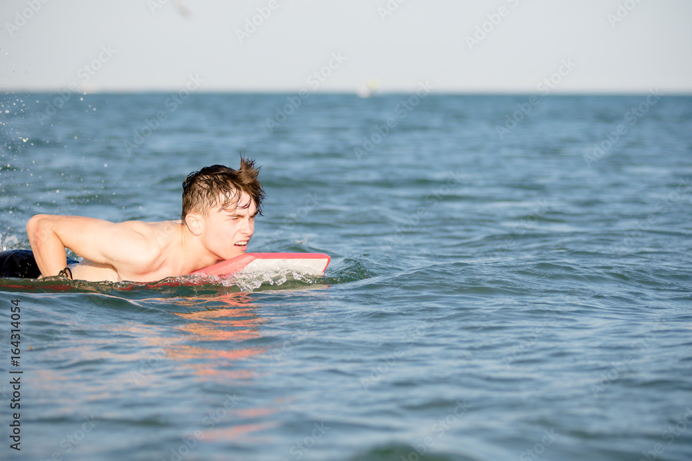 Teenage boy with a body board in the sea