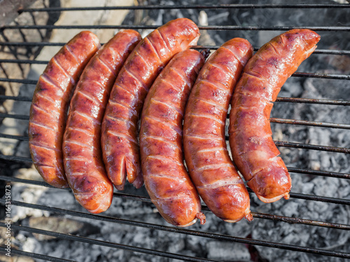 Grilling sausages on barbecue grill 