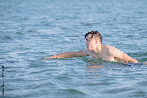 Teenage boy in the sea on a summer s day