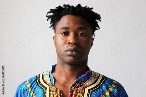 Afrikaner mit traditionell afrikanischer Kleidung und Rastalocken im Portrait