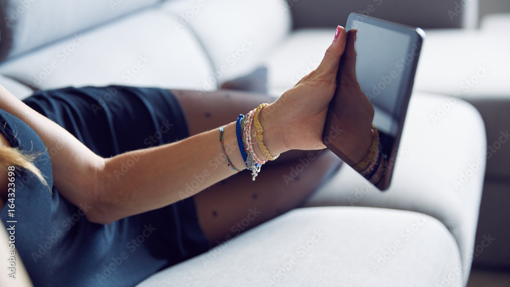 Ragazza con tablet sul divano a casa Ragazza con tablet sul divano a casa