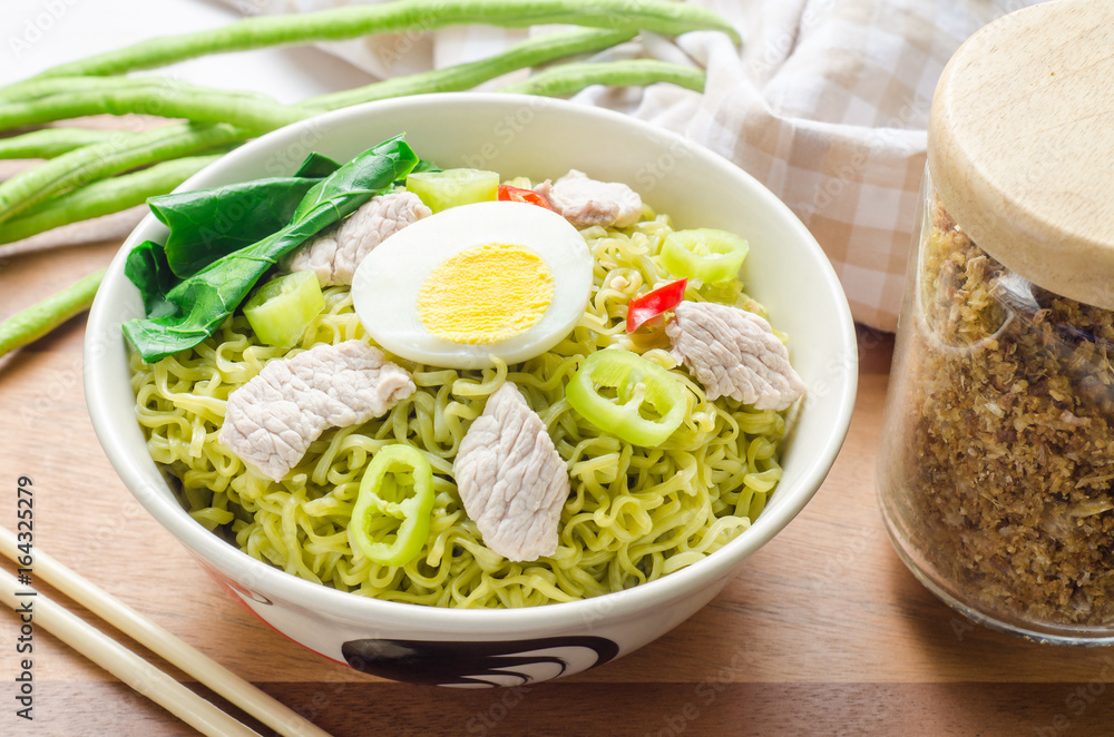 Instant vegetable noodles in a bowl on wooden background. Instant vegetable noodles in a bowl on wooden background.
