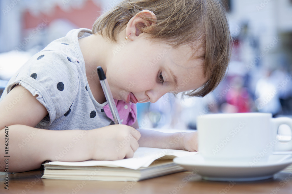 Little business child girl writes in notebook and planning her workday. Humorous picture. Time management, business, job offer, analytics research concept. Little business child girl writes in notebook and planning her workday. Humorous picture. Time management, business, job offer, analytics research concept.