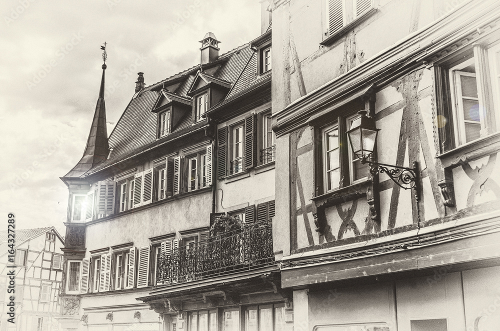 Ancient Europe. A fragment of the old architecture of a building and a lantern in Colmar, France. Photo displayed in old antique style