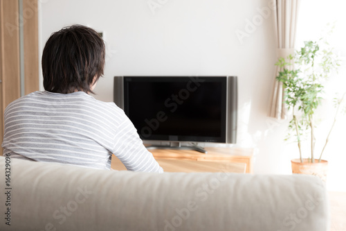 young asian man relaxing in living room