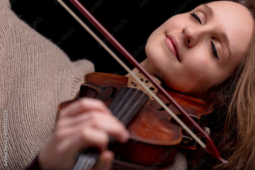 woman playing violin with her eyes closed woman playing violin with her eyes closed