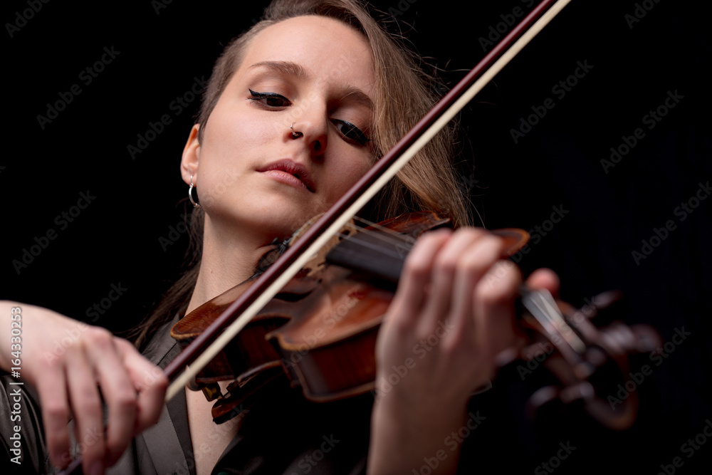 serious pretty woman playing violin on black serious pretty woman playing violin on black