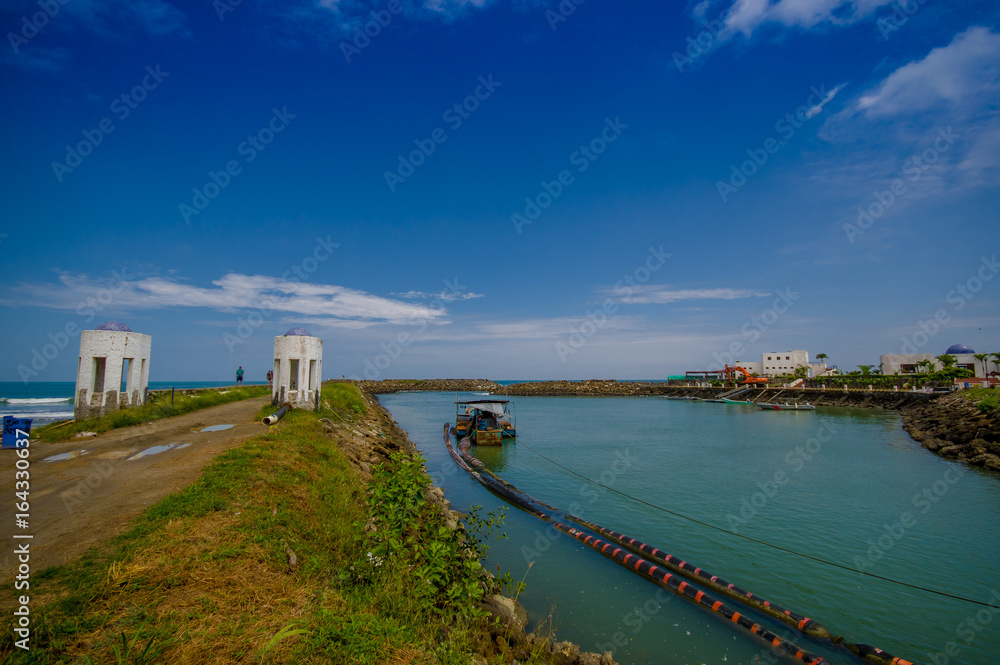 MANABI, ECUADOR - JUNE 4, 2012: Stagnant water with a water pumping machine at Same, Ecuador in a beautiful blue sky in a sunny day