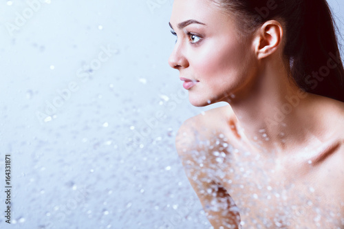 Young beautyful woman under shower in bathroom.