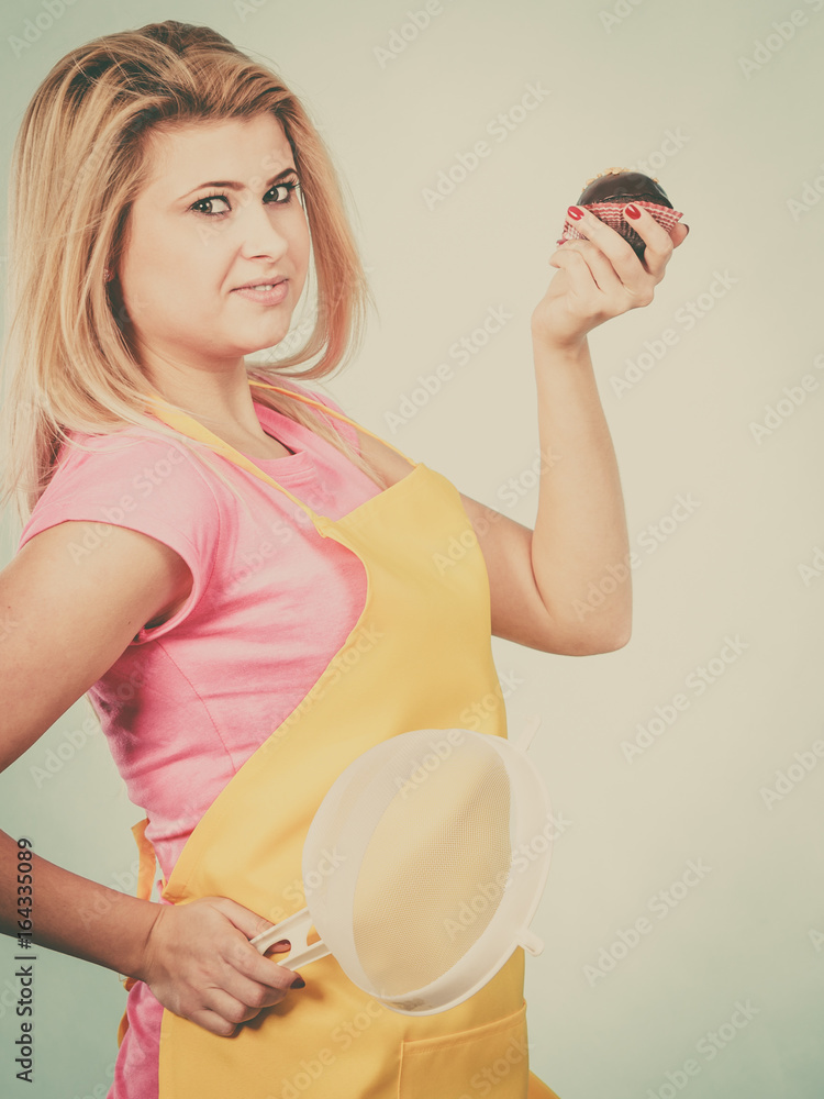 Woman holding chocolate cupcake and colander Woman holding chocolate cupcake and colander