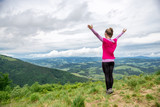 Young woman on the top of mountain