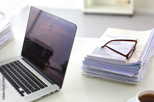 Workplace with notebook laptop Comfortable work table in office windows and city view