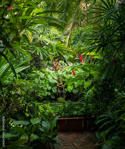 Garden of Jim Thompson House Museum with a Pond and a Woman Statue in Bangkok, Thailand.