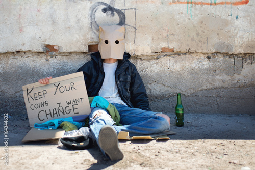 The homeless guy sits at the wall