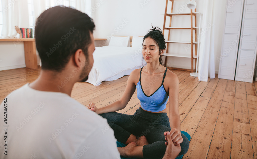 Obraz premium Young couple doing exercise at home