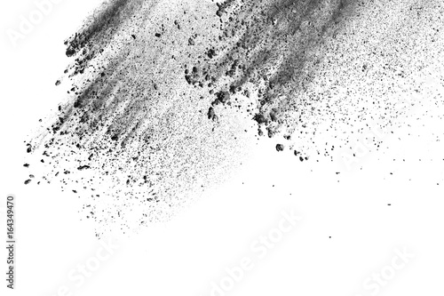 Black powder explosion. Closeup of black dust particles explode isolated on white background. photo
