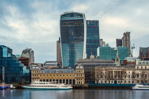 London, England - Panoramic skyline view of the famous Bank district of central London with skyscrapers, boats and blue sky photo