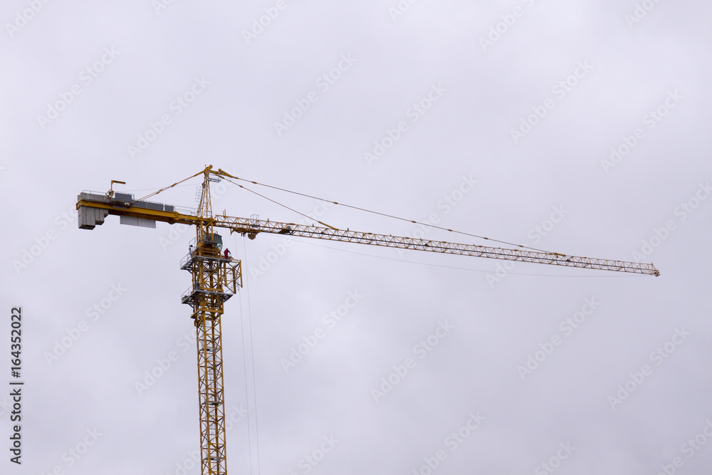 yellow crane on a construction site during the construction of a residential and commercial building yellow crane on a construction site during the construction of a residential and commercial building