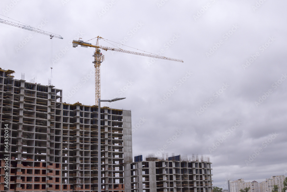 Crane and building construction. New city place for many tall buildings under construction