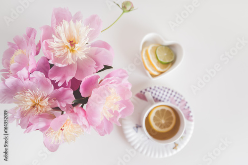 Bouquet of peonies  tea with lemon  photo in gentle colors. Good morning. Have a nice day  Place for text  