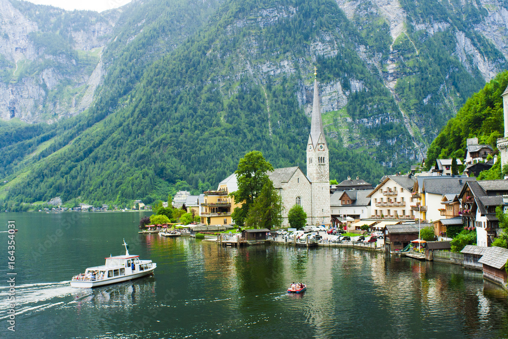 Hallstatt town and lake with boat in Austria, summer view