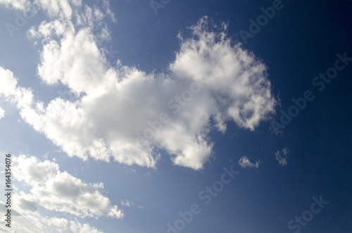 White fluffy clouds in deep blue summer sky