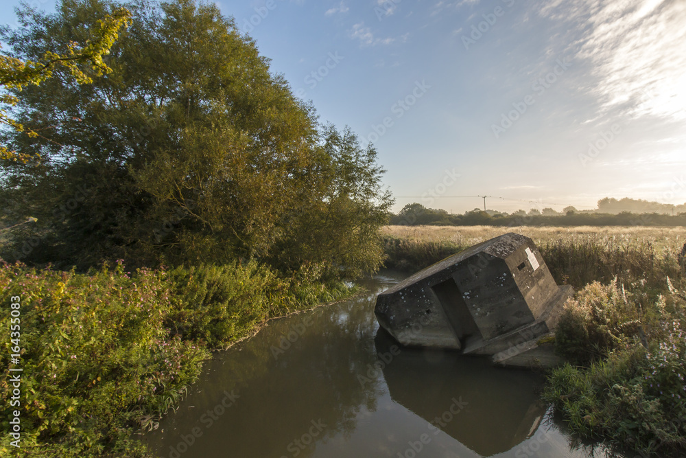 Fototapeta premium Ein vergessener Bunker der umgekippt im Wasser liegt