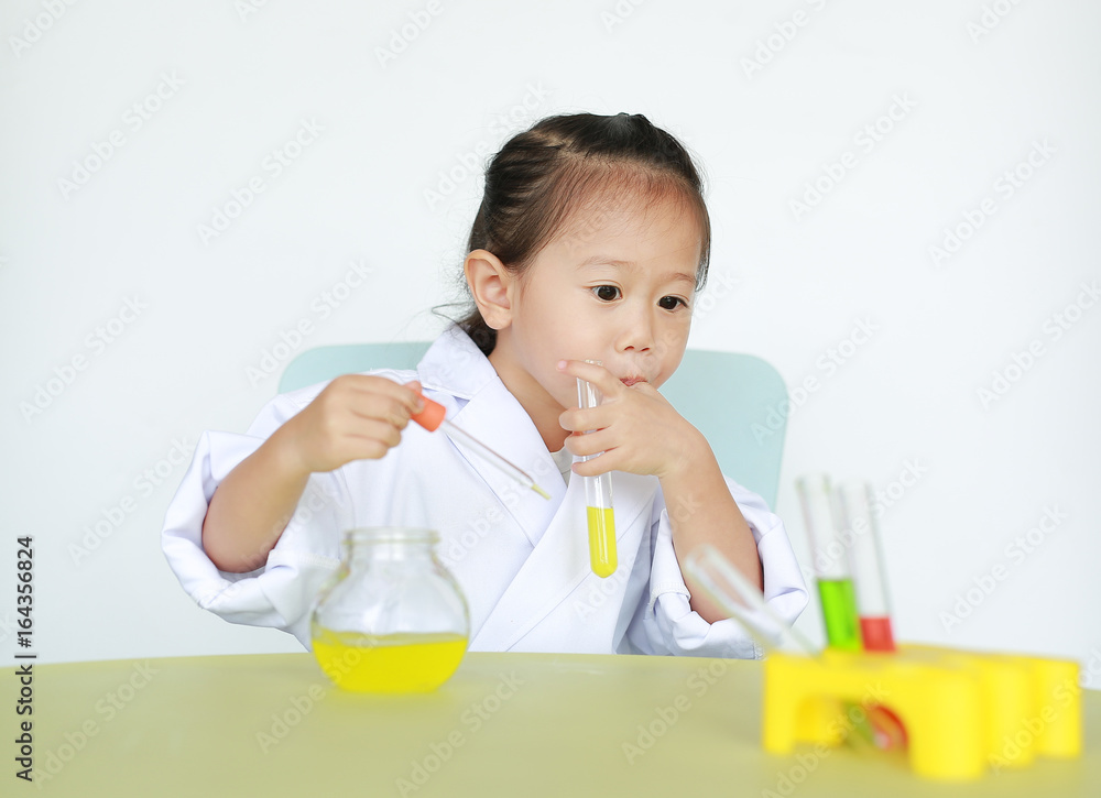 Asian child in scientist uniform holding test tube with liquid isolated on white background. Asian child in scientist uniform holding test tube with liquid isolated on white background.