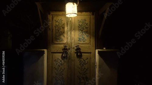 Moving away from the door with large handles and a keyhole in a vintage style.