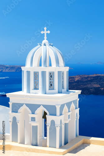 Beautiful striped dome of bell tower of the Church with the magical views of the Caldera Santorini Greece