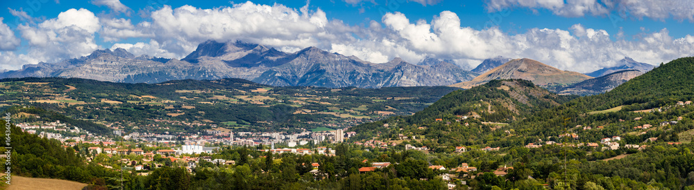 The city of Gap in the Hautes Alpes with surrounding mountains and peaks in Summer. Panoramic. Southern French Alps, France - obrazy, fototapety, plakaty 