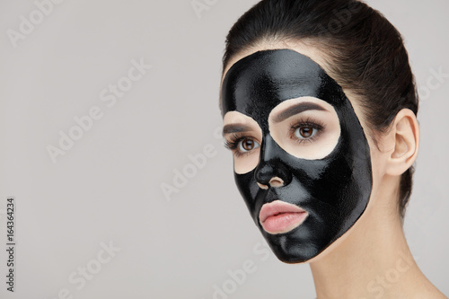 Beauty Face Black Mask. Woman With Black Cosmetic Mask On Skin