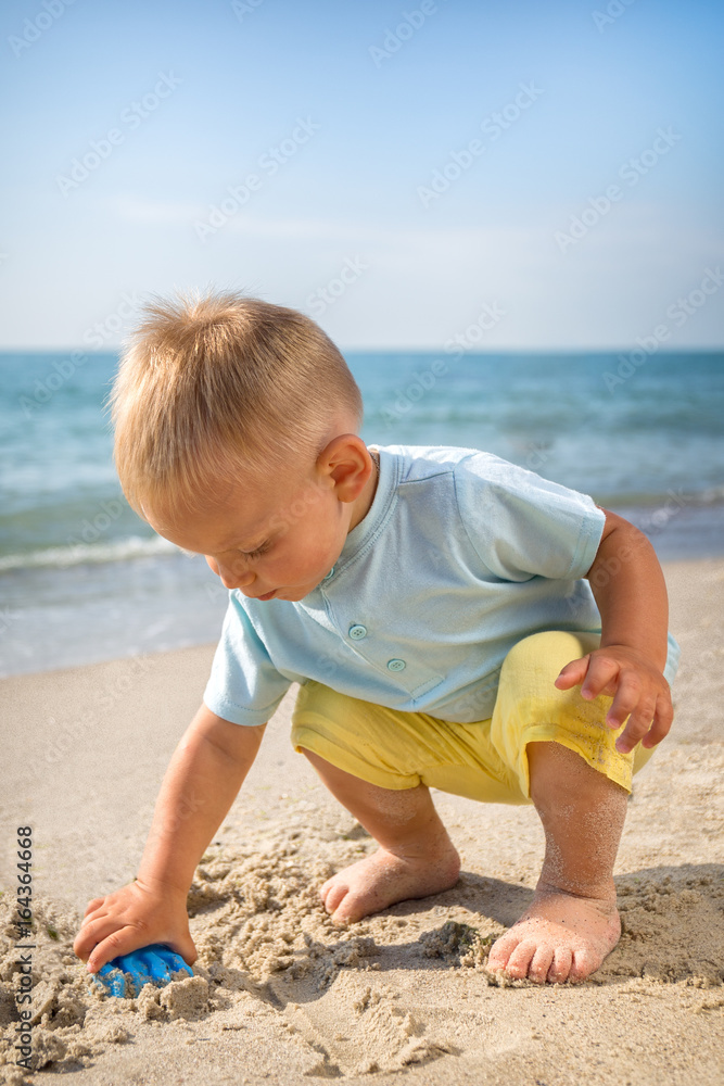 sea ,day,beach ,sand boy playing with a toy sea ,day,beach ,sand boy playing with a toy