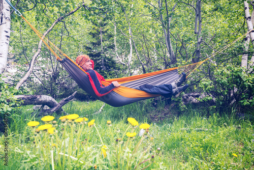 Happy man traveler is relaxing in hammock