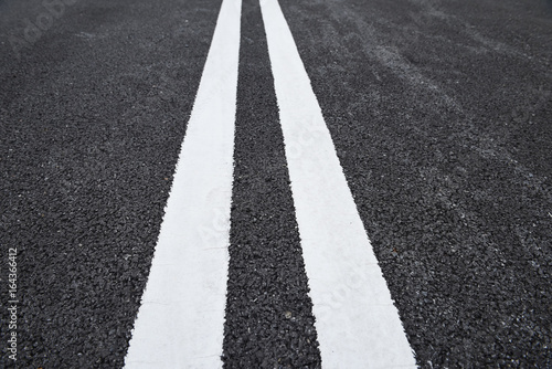 Closeup asphalt road with marking lines for giving directions, traffic lines concept © smshoot