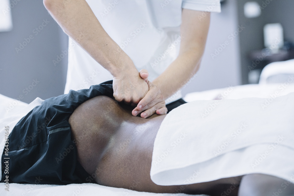 Obraz premium The physiotherapist treating a man using equipment for radio therapy