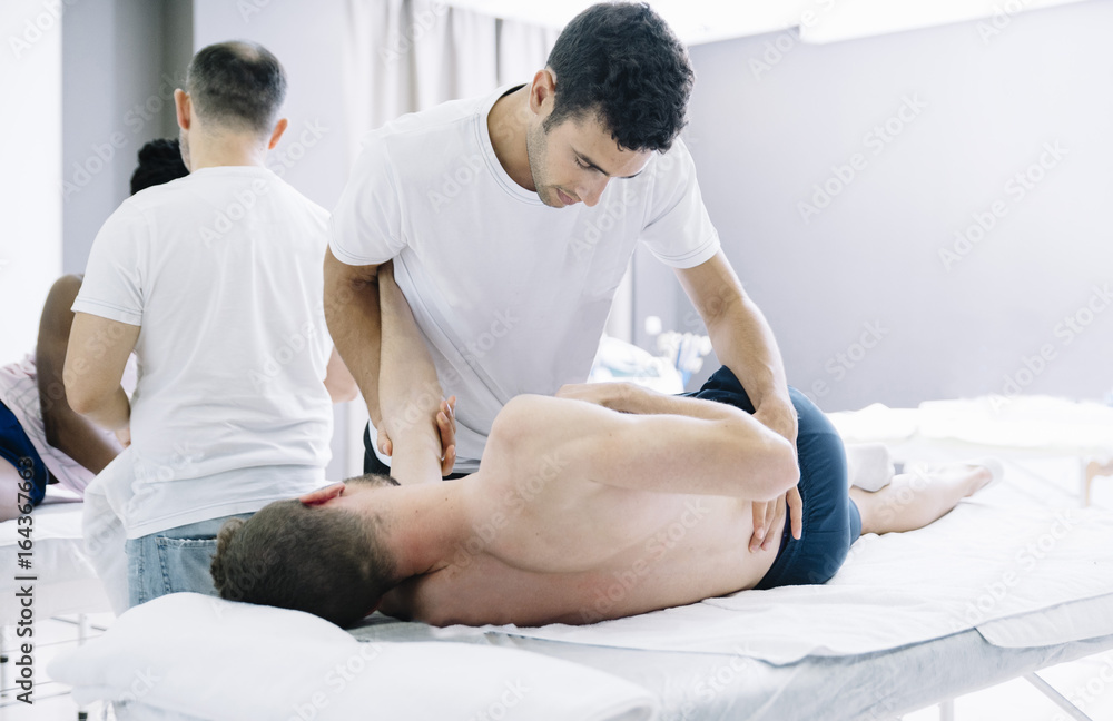 Fototapeta premium The physiotherapist treating a man using equipment for radio therapy