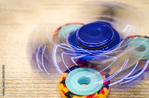 Blue fidget SPINNER stress relieving toy on wood background. photo