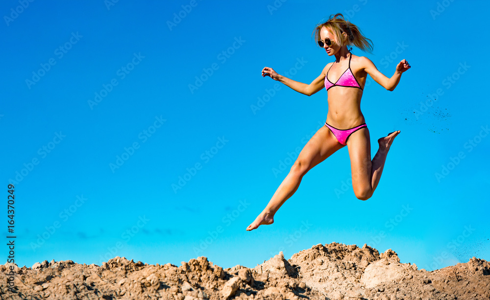 Photo of beautiful young model jumping, in the air, on pile Photo of beautiful young model jumping, in the air, on pile