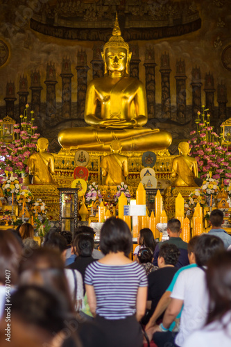 Thai buddhist people pray buddha statue in temple.
