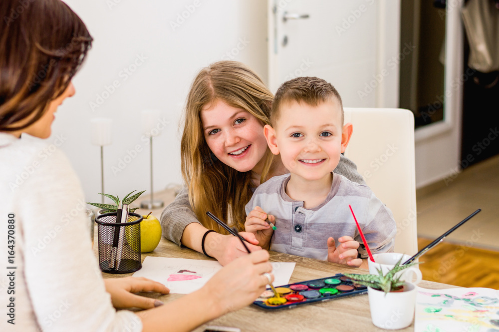 Fototapeta premium Portrait of little kids painting with mom in home