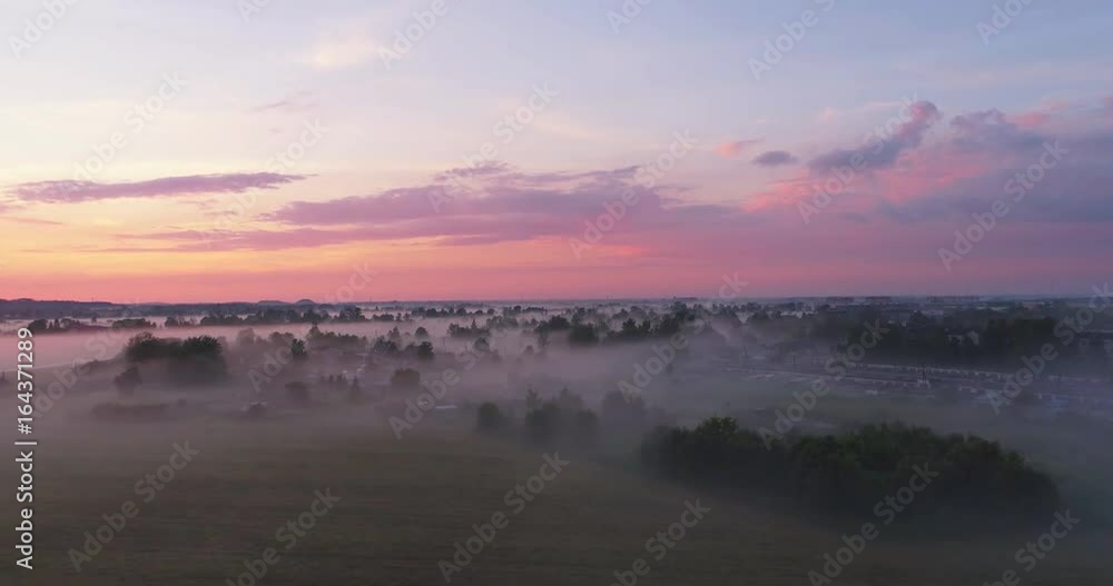 Aerial view flying over beautiful countryside fields through mysterious fog. Beautiful sunset. Aerial view flying over beautiful countryside fields through mysterious fog. Beautiful sunset.