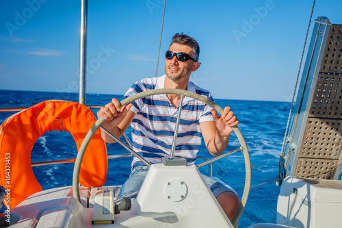 Young man sailing yacht