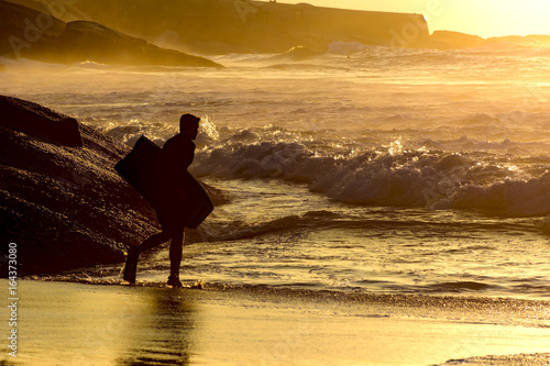 Tableau sur toile Bodyboarder going into the water at Ipanema tropical sunrise in Rio de Janeiro
