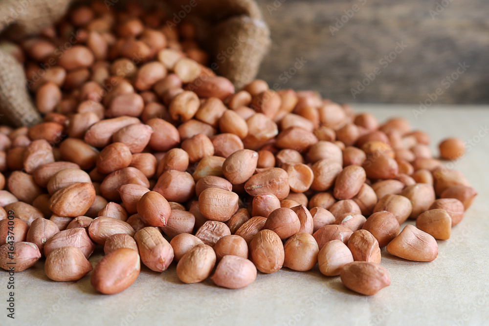 Peanuts in hemp sack on wooden background Peanuts in hemp sack on wooden background