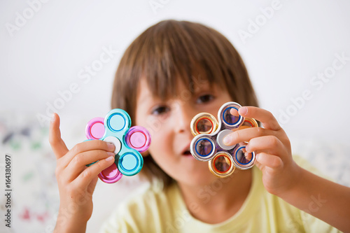 Canvastavla Young boy play with fidget spinner stress relieving toy