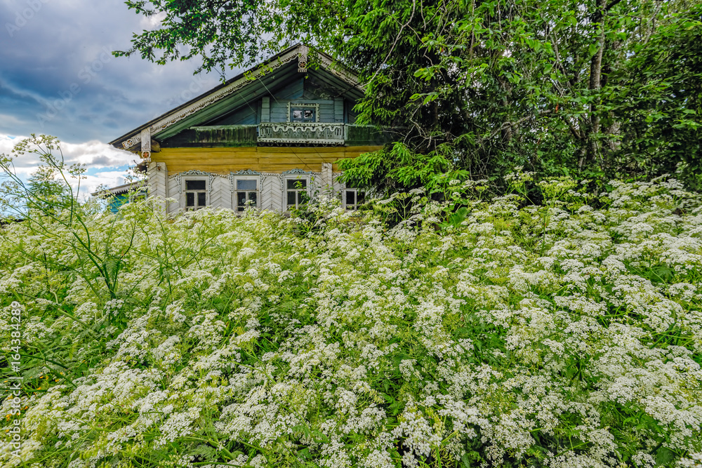 Abandoned old house in a Russian village with ornaments on the facade.