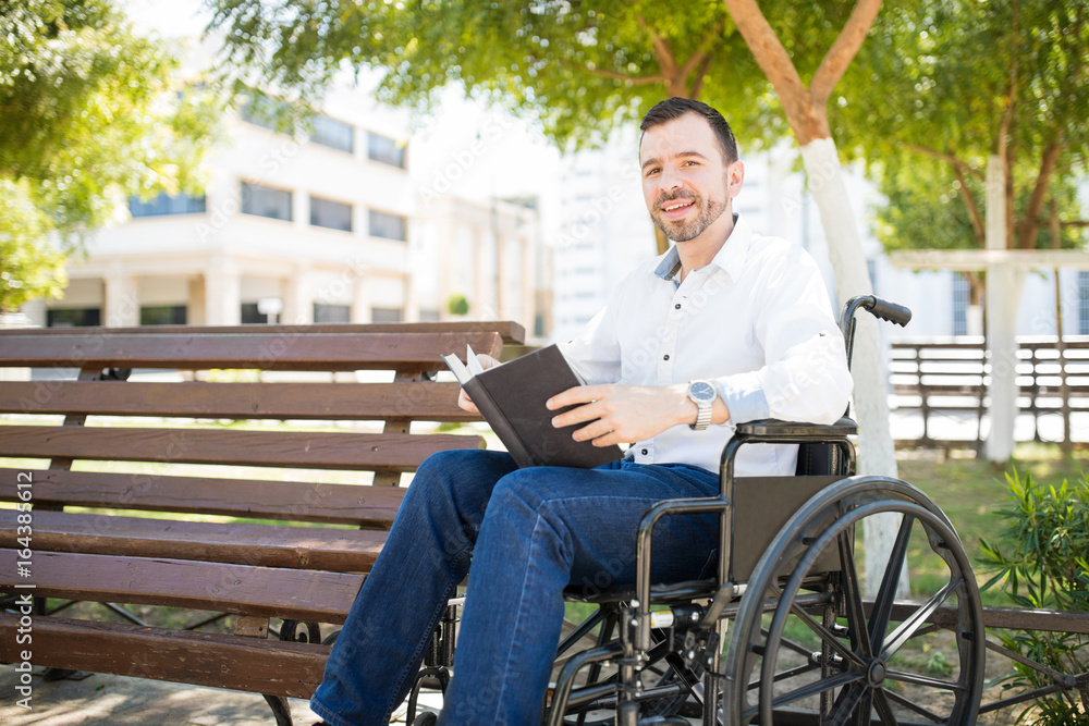Fototapeta premium Happy man reading in a park